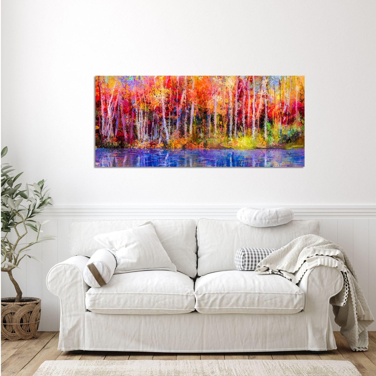 a living room with a white couch and a painting on the wall