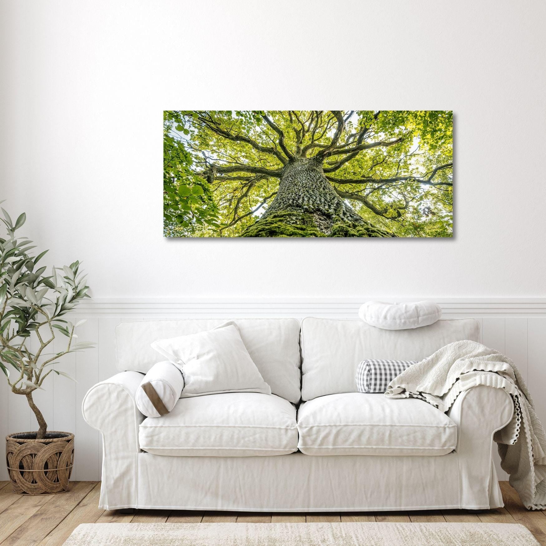 a white couch sitting in a living room under a tree