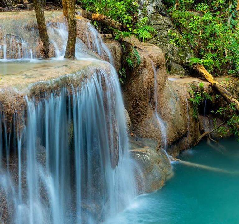 a waterfall in the middle of a pool of water