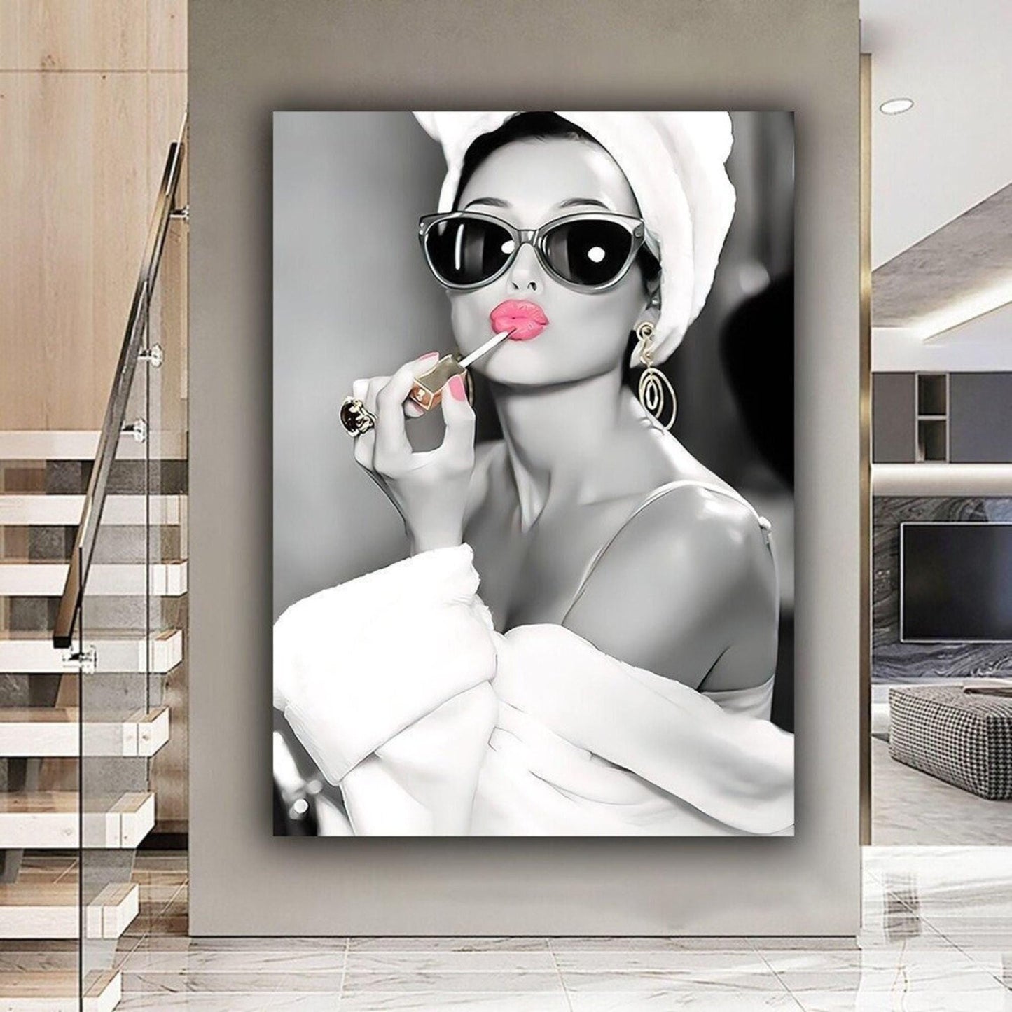 This elegant black-and-white portrait features Audrey Hepburn in a white robe and towel, wearing oversized sunglasses and gold earrings. Her lips and nails are highlighted in bold pink as she applies lipstick, adding a striking pop of colour. The vintage-inspired artwork exudes sophistication and luxury, capturing Hepburn’s timeless Hollywood glamour. A chic, fashion-forward print perfect for modern interiors and fans of iconic beauty.